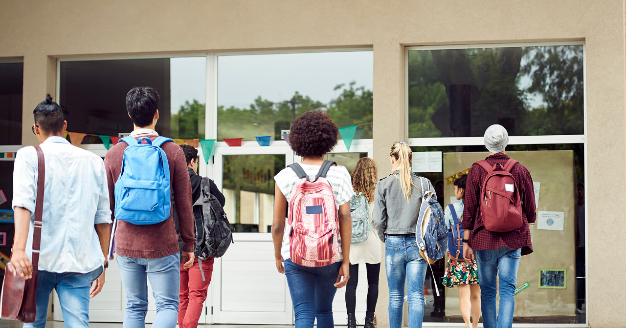 A group of kids with their backs to the camera