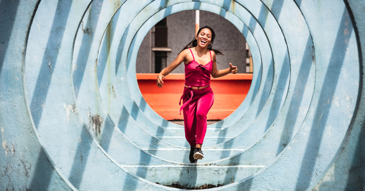 A woman runs through a series of sculptural circles outside. 