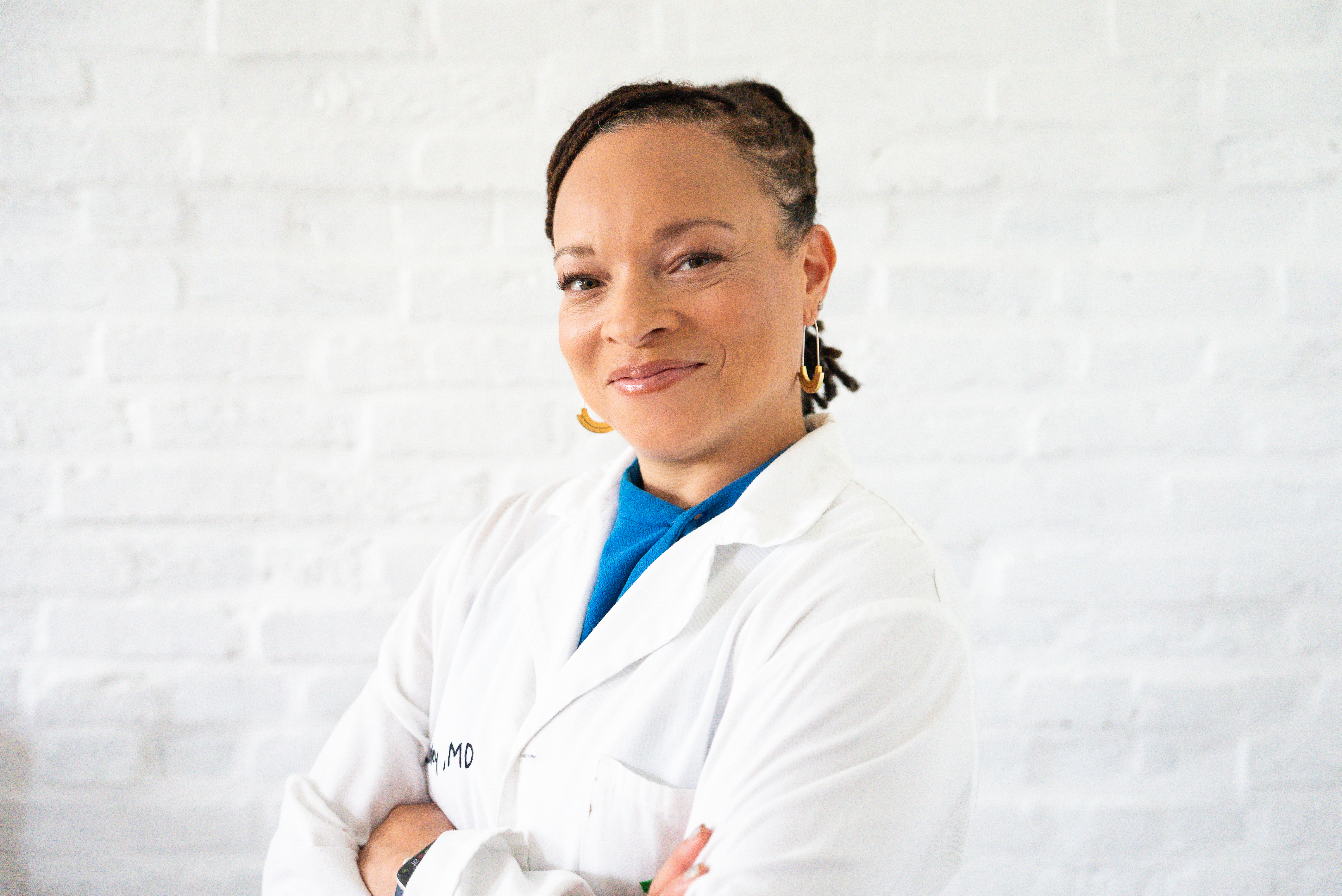 A photo of Dr. Raegan McDonald-Mosley in her white coat, smiling at the camera.