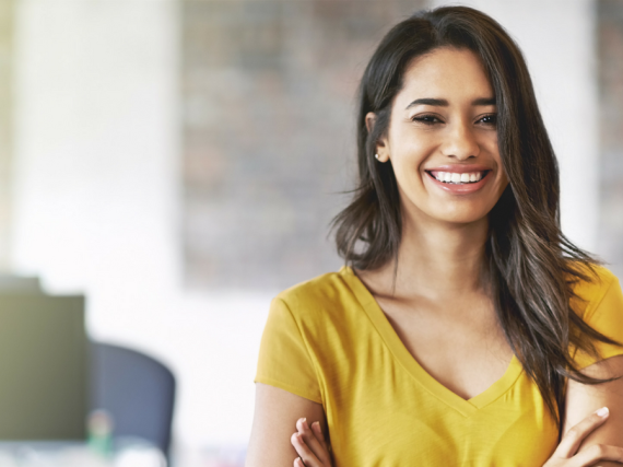A woman with her arms crossed smiles