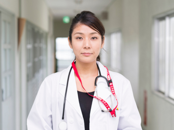 An Asian American doctor looks straight into the camera