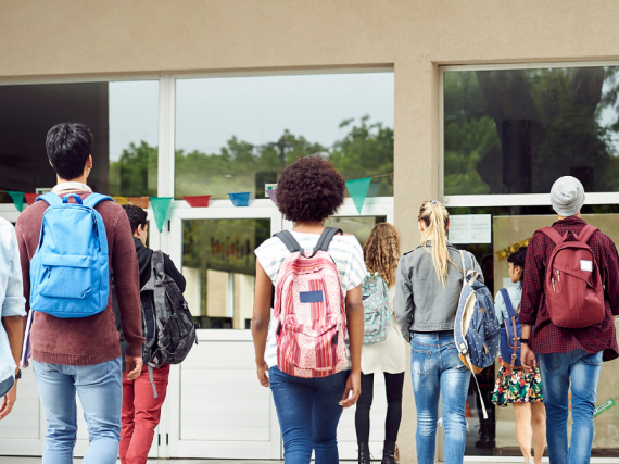 A group of kids with their backs to the camera