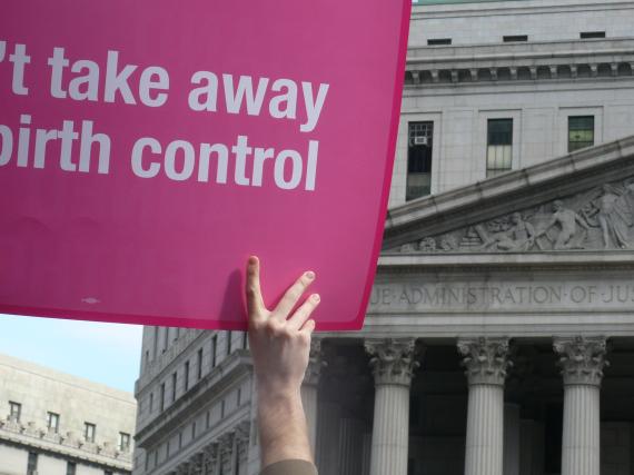 a woman holding a sign that reads, "Don't take away my birth control"