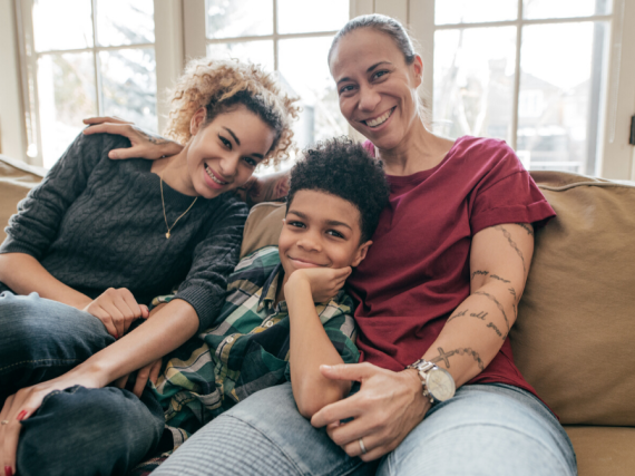 A black mother with her two children, all smiling