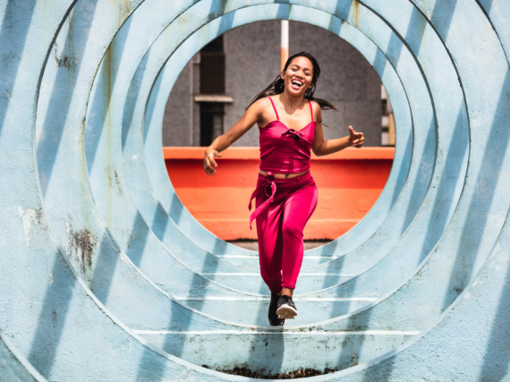 A woman runs through a series of sculptural circles outside. 