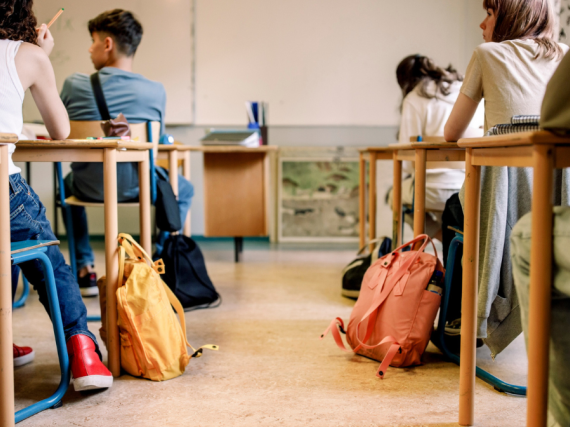 A photo of a full classroom from the back looking towards the board. 