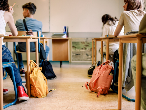 A photo of a full classroom from the back looking towards the board. 
